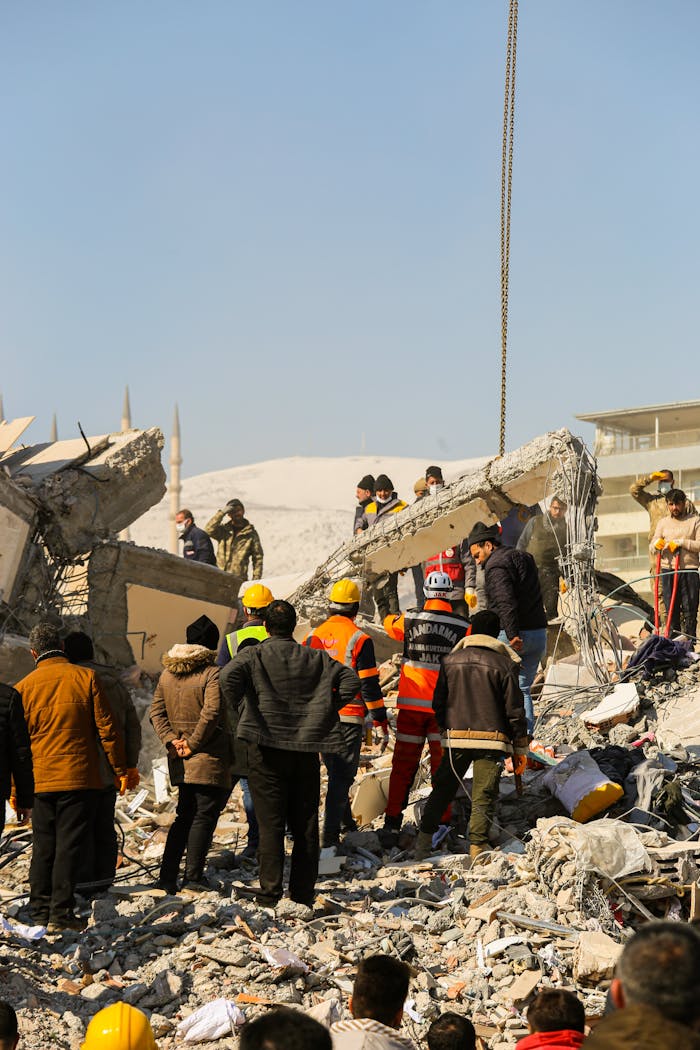 Rescue workers and civilians gathered on rubble after a devastating earthquake in Kahramanmaraş, Türkiye.